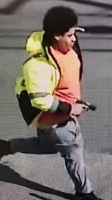 Elvis Adiel Trujillo Guerra, gun in hand, running down a Lawrence street. (U.S. Attorney)